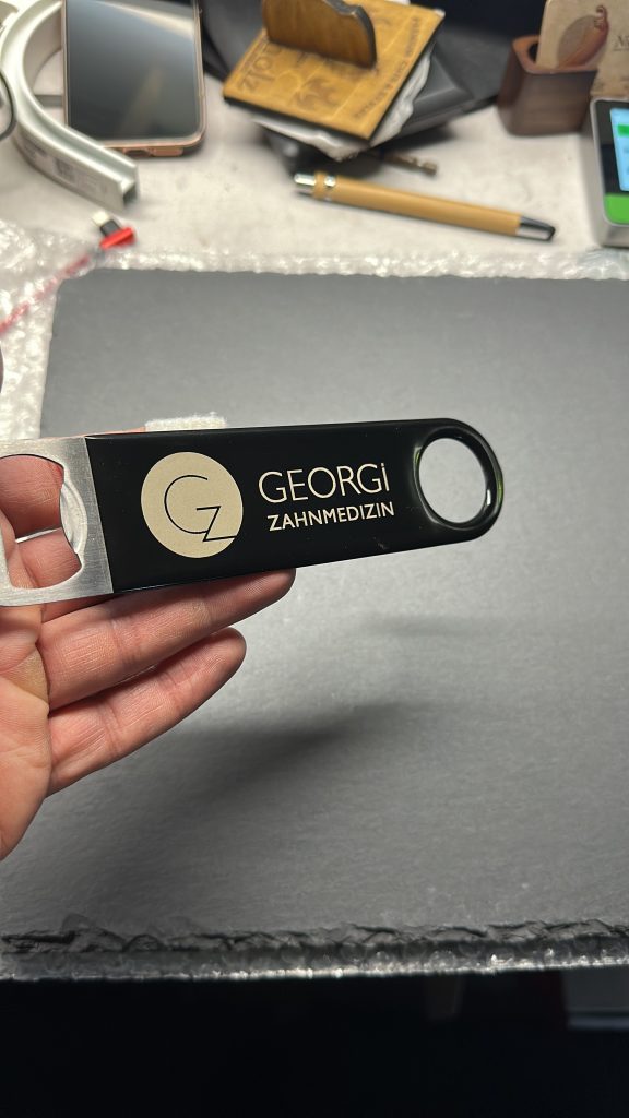 Lasergravur auf Flaschenöffner – individuelles Praxislogo „Georgi Zahnmedizin“ als Werbegeschenk.