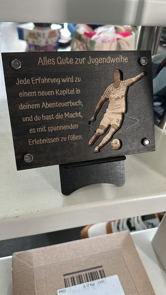 Gravierte Holztafel zur Jugendweihe mit Spruch und Fußballspieler-Motiv.