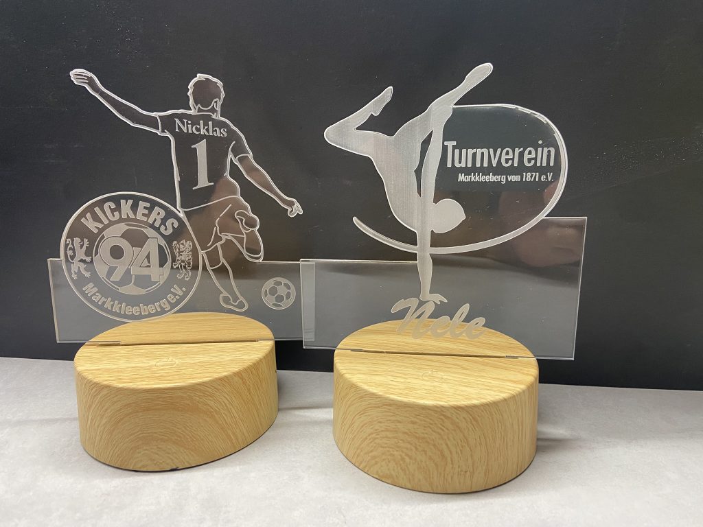 Gravierte Acrylfiguren mit Vereinslogos für Fußball- und Turnverein, personalisiert mit Namen Nicklas und Nele.